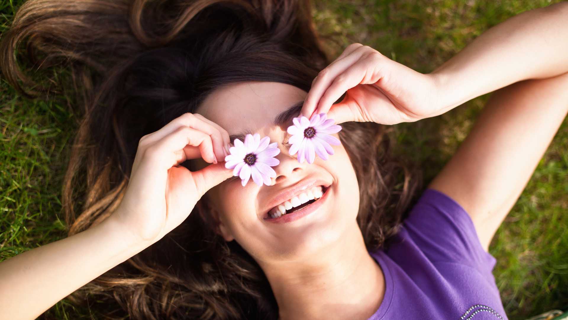 femme qui sourit avec des fleurs